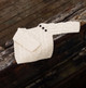 Cream-colored hand-knit baby Aran sweater with traditional cable patterns and shoulder buttons, displayed on rustic wooden surface – cozy Irish knitwear for infants. Cream-colored hand-knit baby Aran sweater with traditional cable patterns and shoulder buttons, displayed on rustic wooden surface – cozy Irish knitwear for infants.
